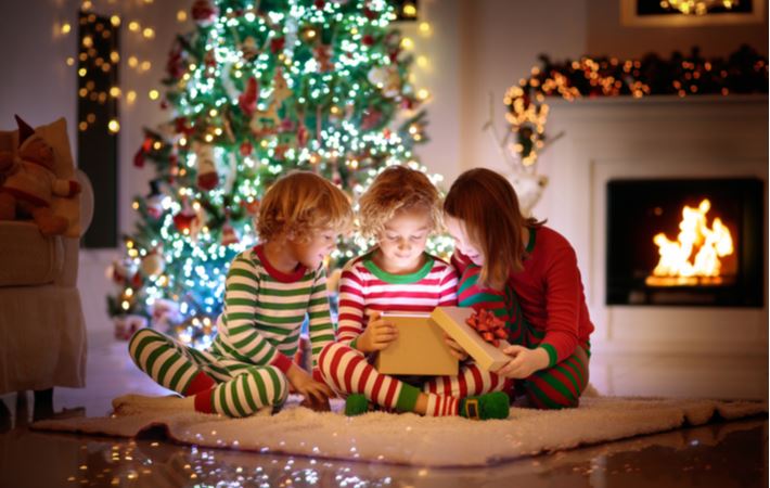 Children opening Christmas presents in the comfort of their living room