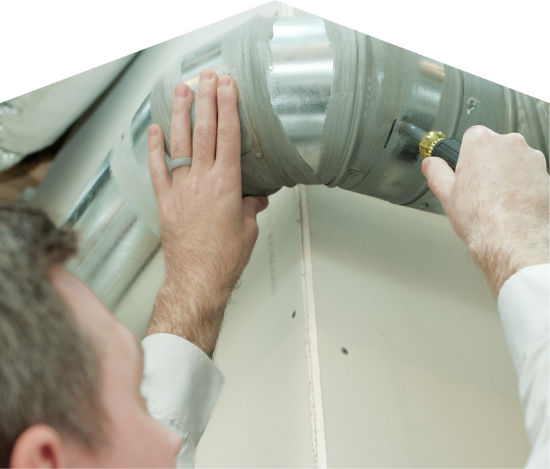 Mr. Furnace HVAC technician inspecting and tightening a joint on a sealed metal air duct, performing maintenance work during an air duct cleaning task. Mr. Furnace HVAC technician inspecting and tightening a joint on a sealed metal air duct, performing maintenance work during an air duct cleaning task.