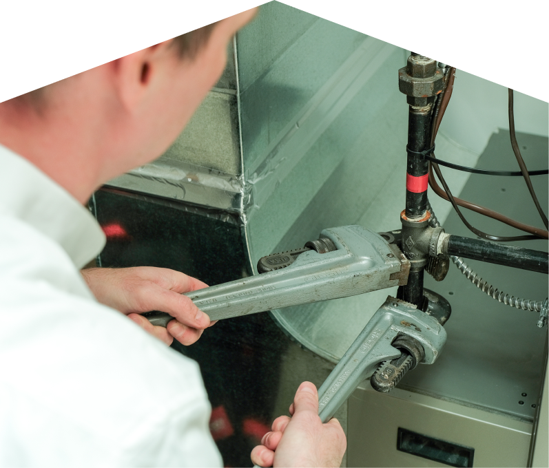 Mr. Furnace emergency plumber using two pipe wrenches to tighten a pipe connection beside HVAC ductwork during urgent service work. Mr. Furnace emergency plumber using two pipe wrenches to tighten a pipe connection beside HVAC ductwork during urgent service work.