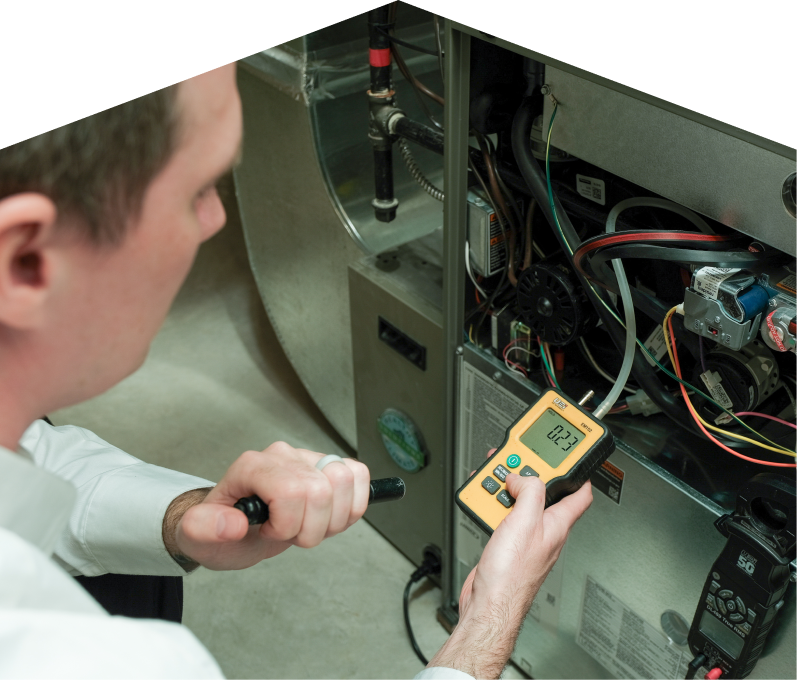 Mr. Furnace HVAC specialist performing furnace repair on a heating system, using a digital manometer to check pressure. Mr. Furnace HVAC specialist performing furnace repair on a heating sy