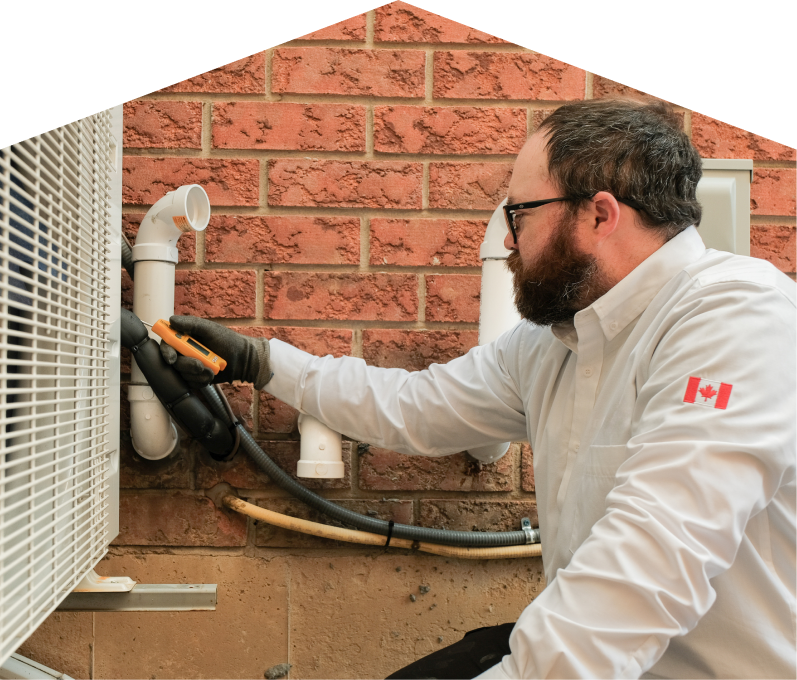 Mr. Furnace HVAC specialist checking insulated piping on a heat pump unit beside a brick wall during a diagnostic service. Mr. Furnace HVAC specialist checking insulated piping on a heat pump unit beside a brick wall during a diagnostic service.
