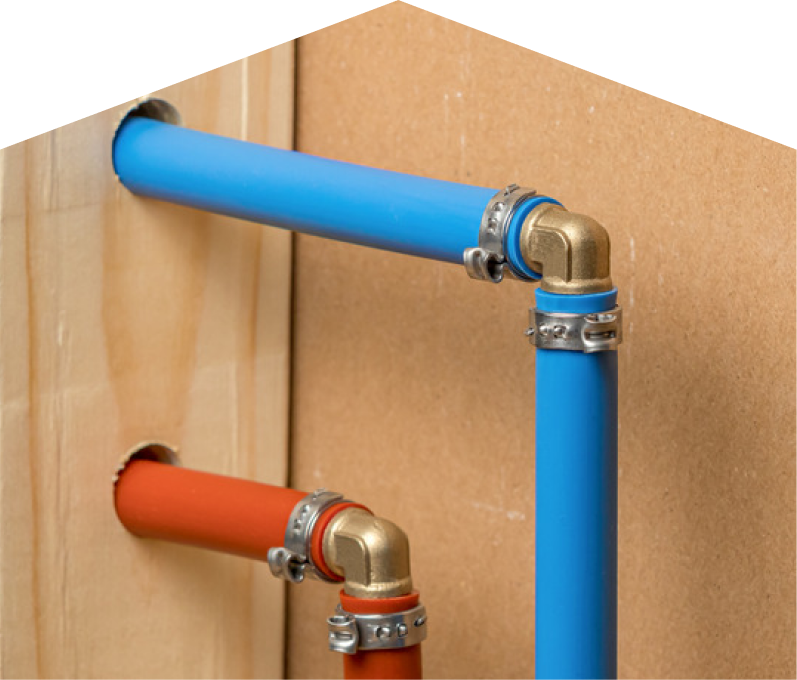 Mr. Furnace kitec plumbing system with blue and orange plastic pipes connected by brass fittings and metal clamps, mounted on a wooden panel. Mr. Furnace kitec plumbing system with blue and orange plastic pipes connected by brass fittings and metal clamps, mounted on a wooden panel.