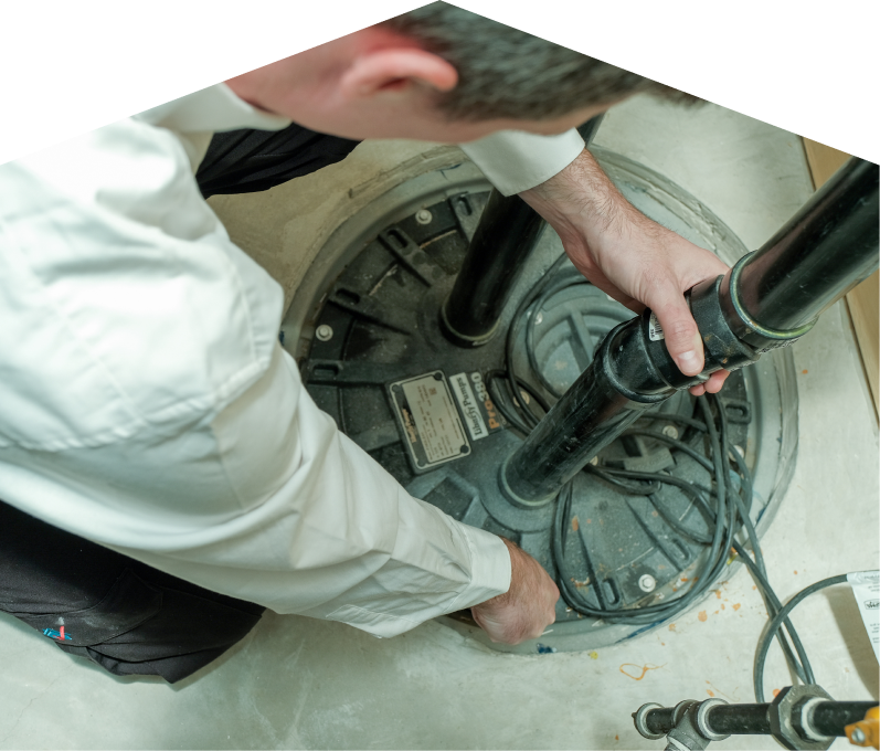 Mr. Furnace sump pump specialist secures discharge piping on a sealed basin during a sump pump installation in a basement utility area. Mr. Furnace sump pump specialist secures discharge piping on a sealed basin during a sump pump installation in a basement utility area.