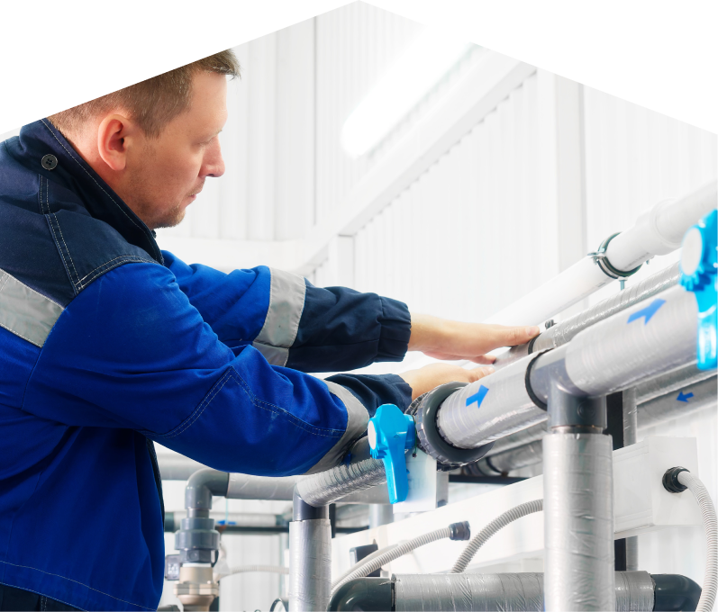 Mr. Furnace water damage and restoration specialist in a blue uniform adjusts insulated piping on a water system inside a bright utility room. Mr. Furnace water damage and restoration specialist in a blue uniform adjusts insulated piping on a water system inside a bright utility room.