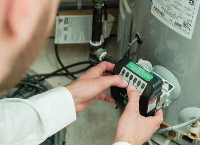 A Mr. Furnace technician adjusts the control module on a residential water heater, verifying proper operating settings. A Mr. Furnace technician adjusts the control module on a residential water heater, verifying proper operating settings.